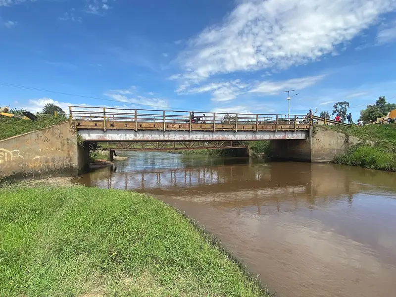 The River Rwizi flowing beneath a concrete road bridge at Katete, Mbarara, with dense green vegetation on both banks